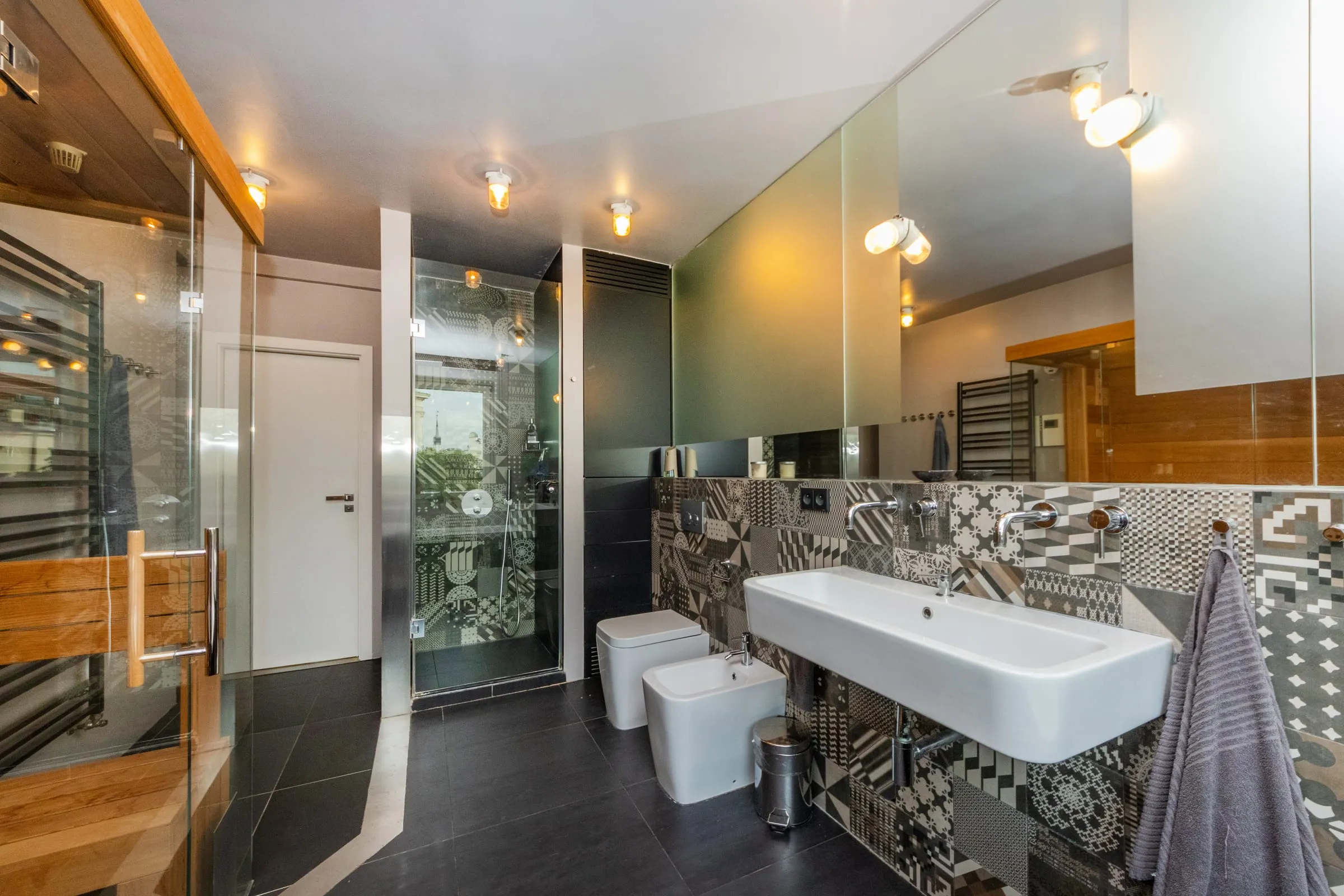 Bathroom with a walk-in shower, a bidet and two sinks