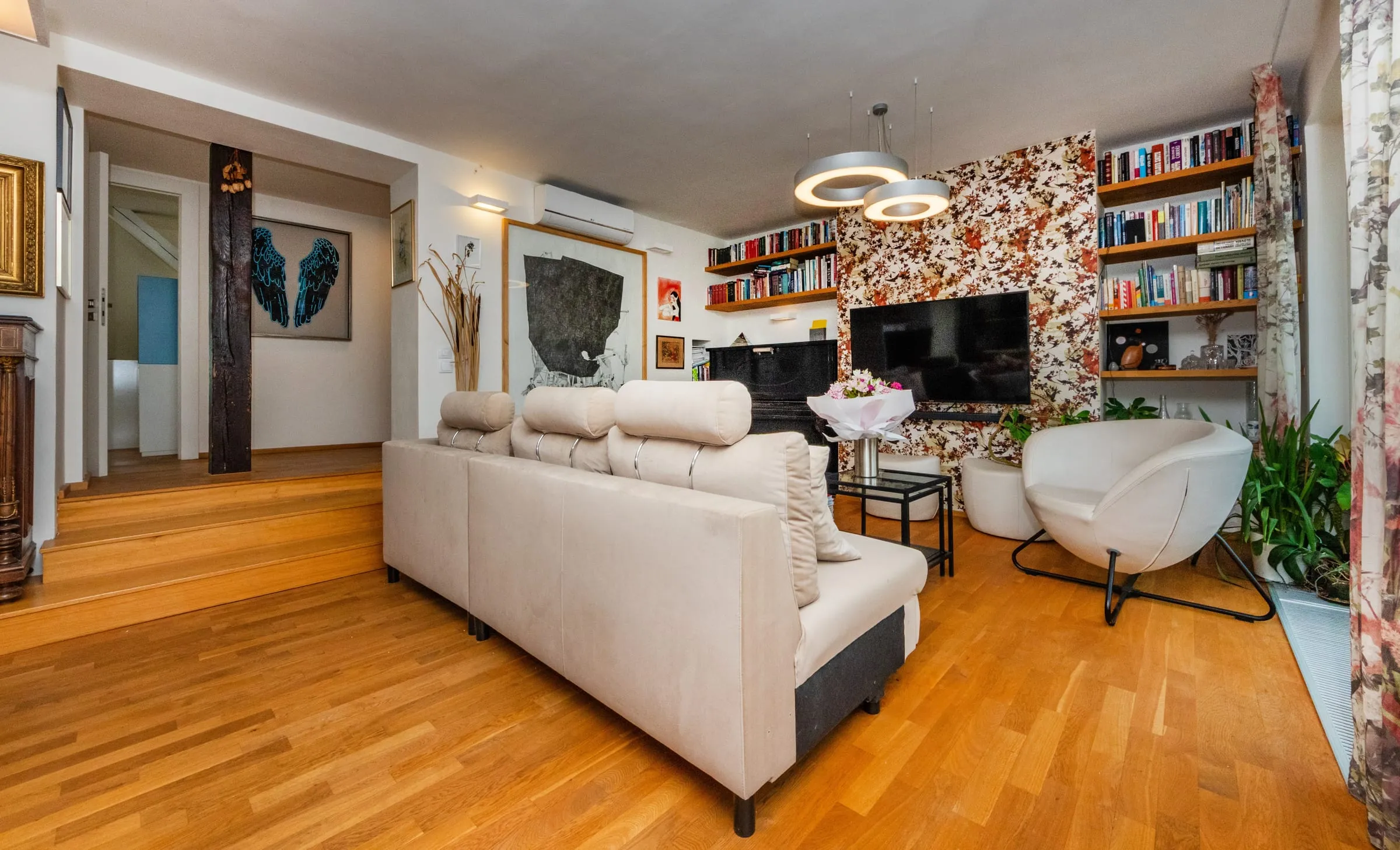 Sofa corner with bookshelves and artwork in the downstairs living room