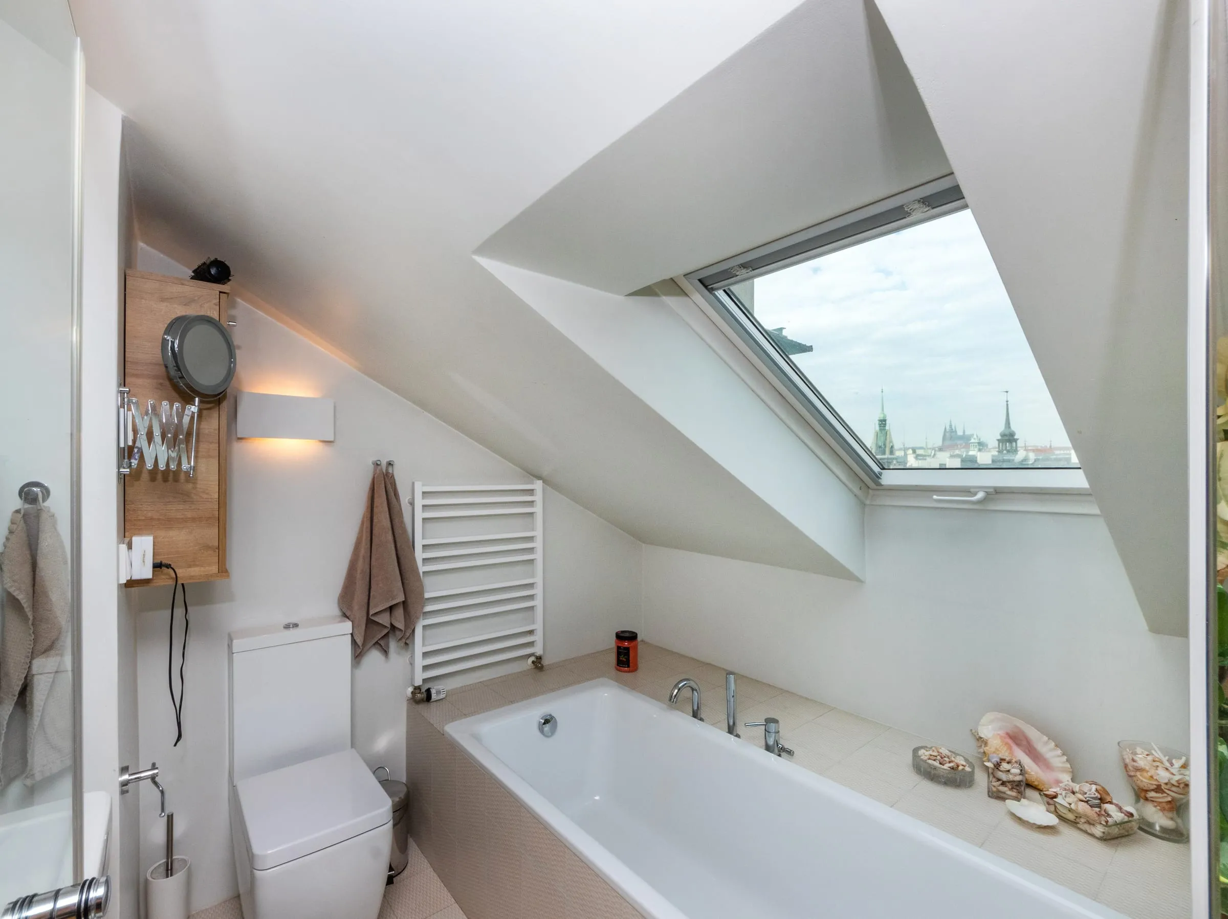 Bright bathroom with a tub under a roof window