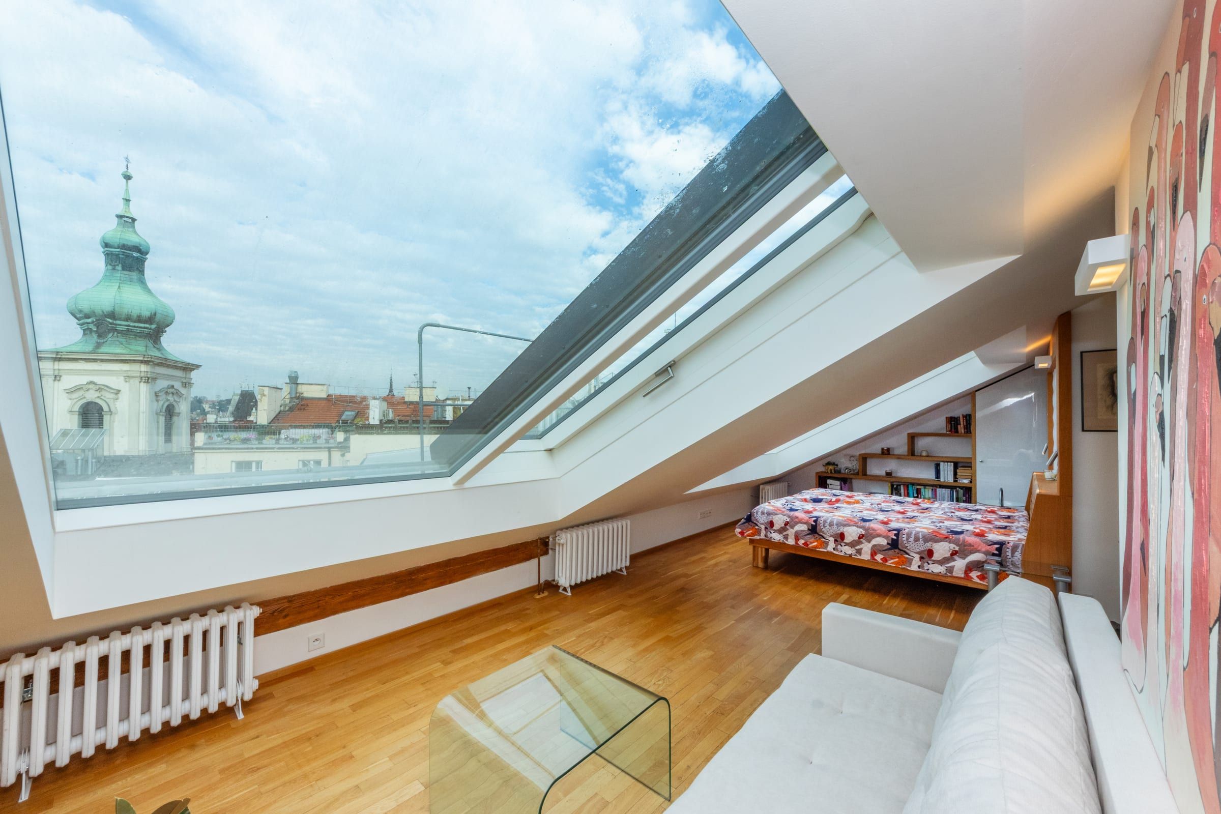 Attic lounge with a sofa and skylights opening onto the Old Town towers